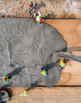 Construction Worker Pouring A Wet Concrete At Road Construction Site